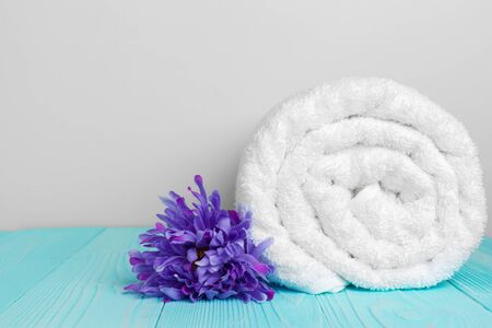 clean soft towels with flower on wooden tableの写真素材