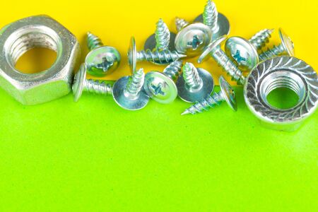 Top view of stainless steel bolts or iron nails on bright green background. Close up.の写真素材