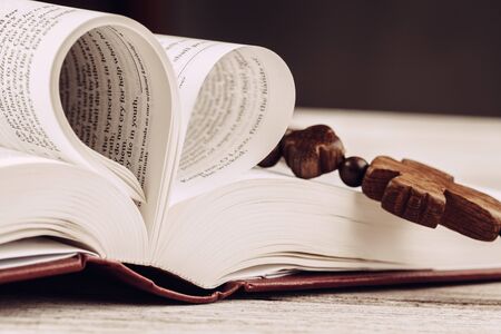 Bible and a crucifix on an old wooden table. Religion concept.の写真素材