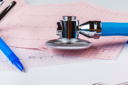 Stethoscope on cardiogram sheet. Close up.