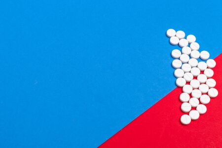 White medical pills on a two color red and blue background