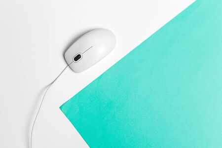 Computer mouse on a turquoise paper background. Close up.