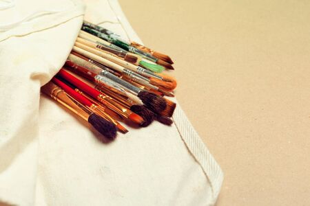 Set of professional watercolor artist brushes in a hand made roll case and watercolor paints close upの写真素材