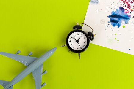 Time to travel concept. plastic plane jet toy passenger with alarm clock. Close up.の写真素材