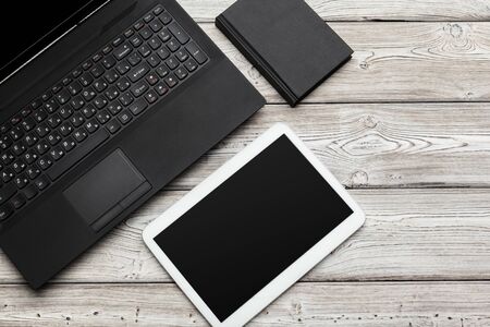 Open laptop with digital tablet on the table. Close up.