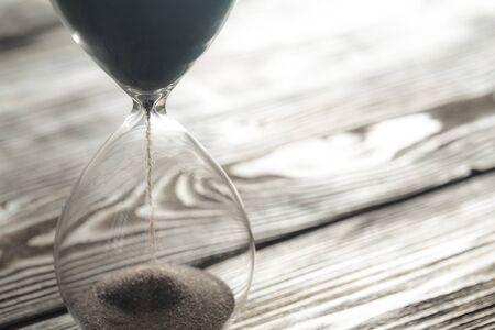 Modern hourglass on wooden background