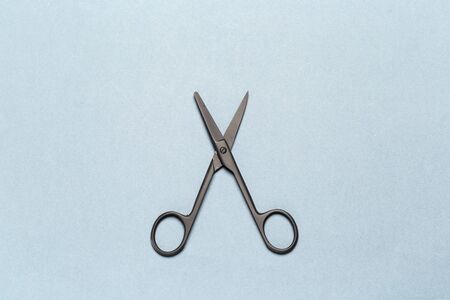 Black metal open scissors on light gray background. Close up.