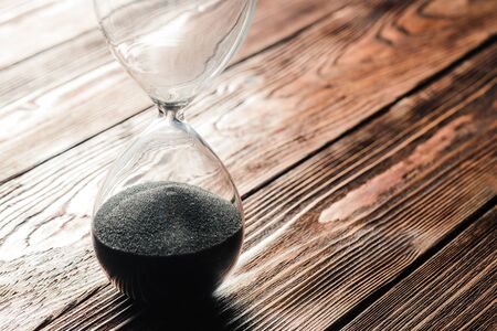 Modern hourglass on wooden background