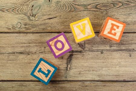 Word love from children's wooden blocks on wooden background. Close up.の写真素材