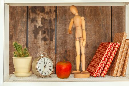 Close up of white bookshelf against grunge wooden wall. Close up.の写真素材