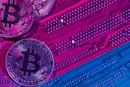 golden bitcoin and computer chip in background. Close up.の写真素材
