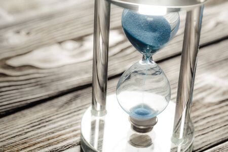 Modern hourglass on wooden backgroundの写真素材