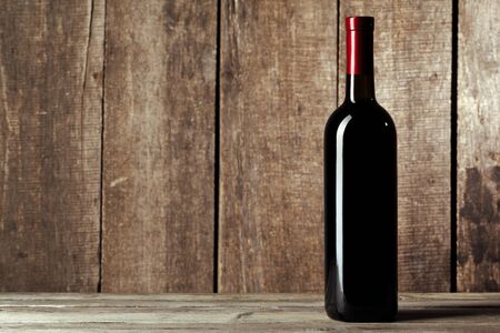 bottle of wine over wooden background. Close up.の写真素材