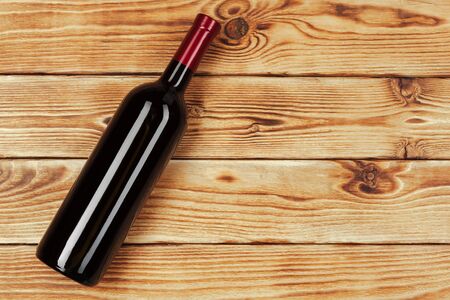bottle of wine over wooden background. Close up.の写真素材
