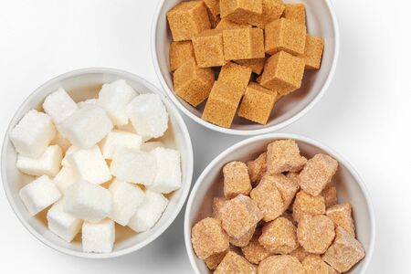 White refined sugar and brown unrefined sugar cubes. Close up.