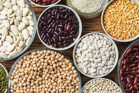Assortment of beans on wooden background.