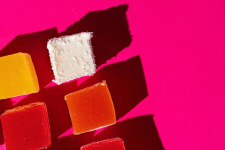 Turkish delight square pieces on a bright pink backgroundの写真素材