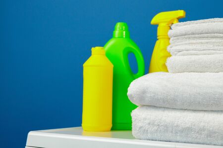 Bottle of detergent whith washing machine, indoors. Close up.