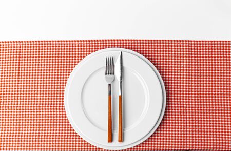 Fork, knife and plate on towel. Isolated on white background. Close up.の写真素材