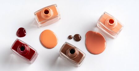 Nude colors nail polish spilled over white backgroundの写真素材