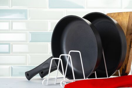 Clean and dry cooking pans on a kitchen counter. Close up.