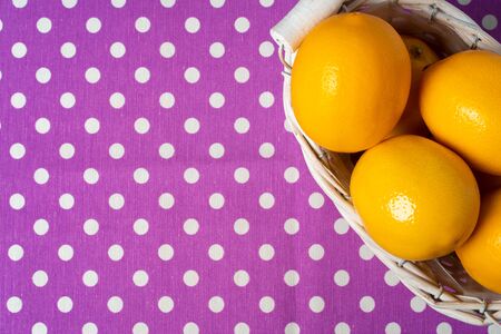 Basket of lemons on dotted purple tableclothの写真素材