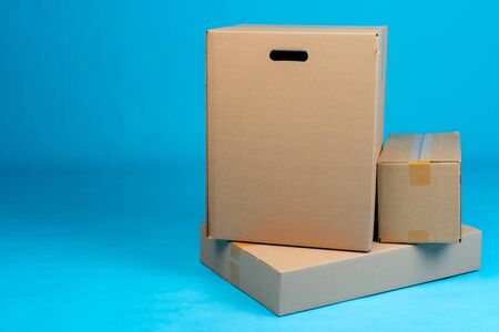 Stack of cardboard boxes on blue background. Close up.