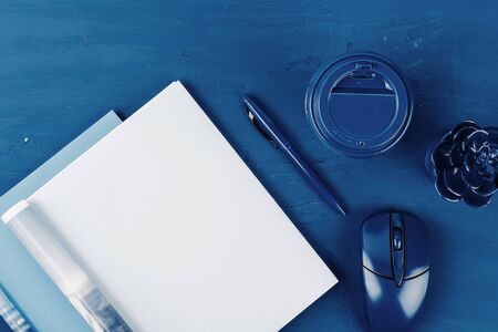Top view of open magazine page with copy space on classic blue background