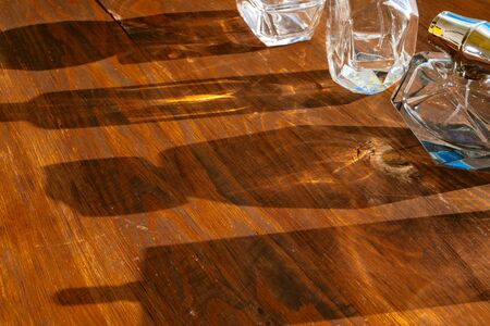 Set of perfume bottles on a bright light with shadows. Close up.の写真素材