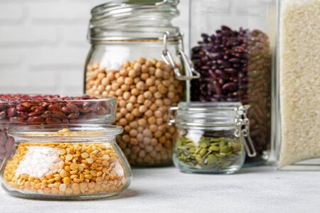 Raw cereals or beans in glass jars close up. Vegan and vegetarian food.の写真素材