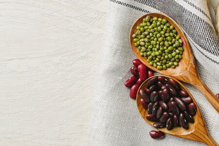 dried beans in wooden spoons on the table