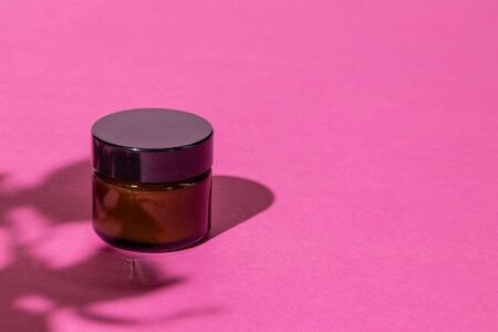 Skincare products containers on bright pink backgroundの写真素材