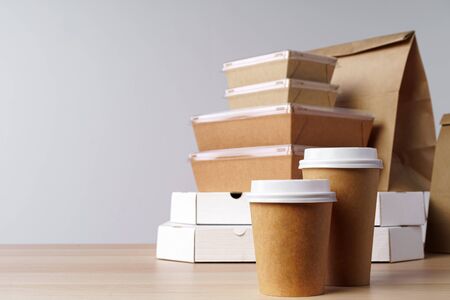Many various take-out food containers, pizza box, coffee cups and paper bags on light grey background. Food deliveryの写真素材