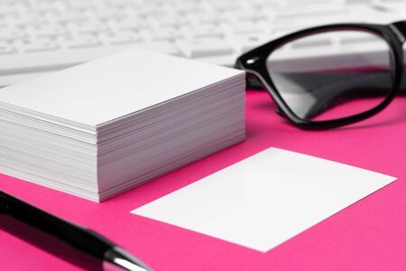 Blank business cards with supplies and keyboard on office table. Close up.の写真素材