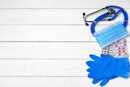 Medical equipment. Stethoscope, mask and pills on wooden desk close upの写真素材