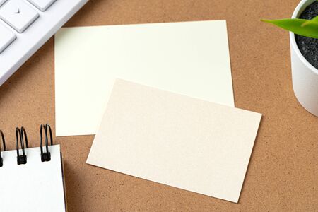 Blank business cards with supplies and keyboard on office table.