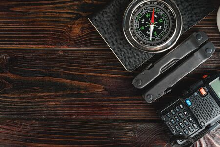 Compass surrounded by mountain gear tools on wooden backgroundの写真素材