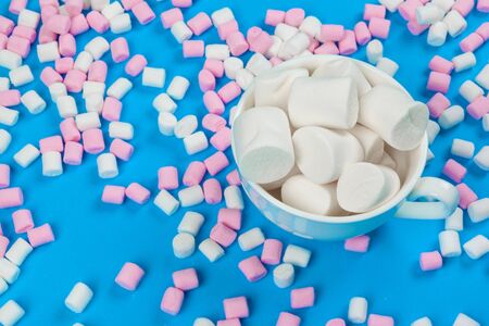 marshmallow laid out on blue paper background. pastel creative textured pattern.の写真素材
