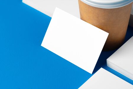 Blank takeaway coffee cup and white businesscards with copy spaceの写真素材