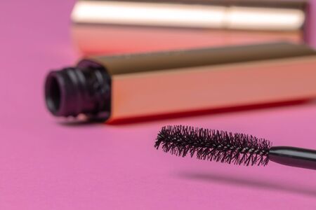 Open gold tube of mascara close up on pink backgroundの写真素材