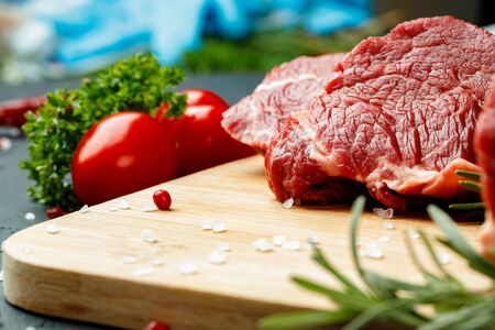 Slice of raw beef fillet on wooden board close upの写真素材