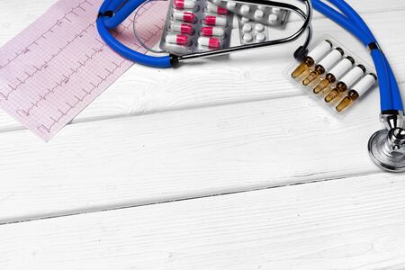 Medical equipment. Stethoscope, mask and pills on wooden desk close upの写真素材