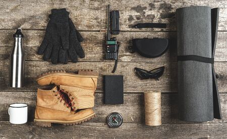 Top view of assorted hiking equipment tools on grunge wooden backgroundの写真素材