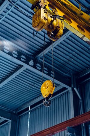 Industrial crane hook in a modern factory buildingの写真素材
