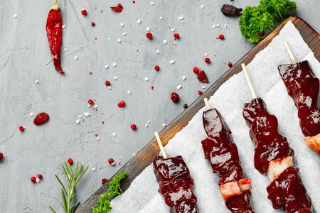 Raw liver kebab on skewers on wooden boardの写真素材