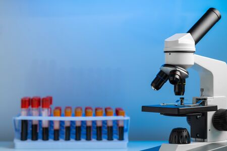 Laboratory microscope with colorful test tubes close up