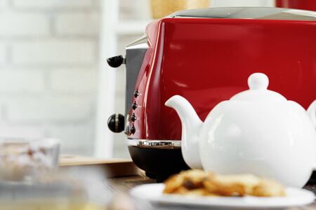 Ceramic teapot and toaster, kitchen table close upの写真素材