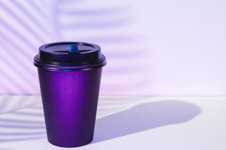 Takeout coffee cup with foliage shadows, copy spaceの写真素材