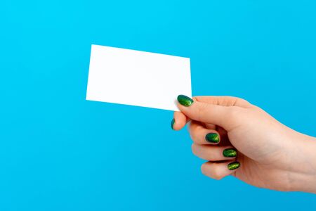 Woman hand holding blank card on blue backgroundの写真素材