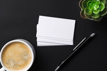 Top view of cup with espresso and white business card template on black tableの写真素材